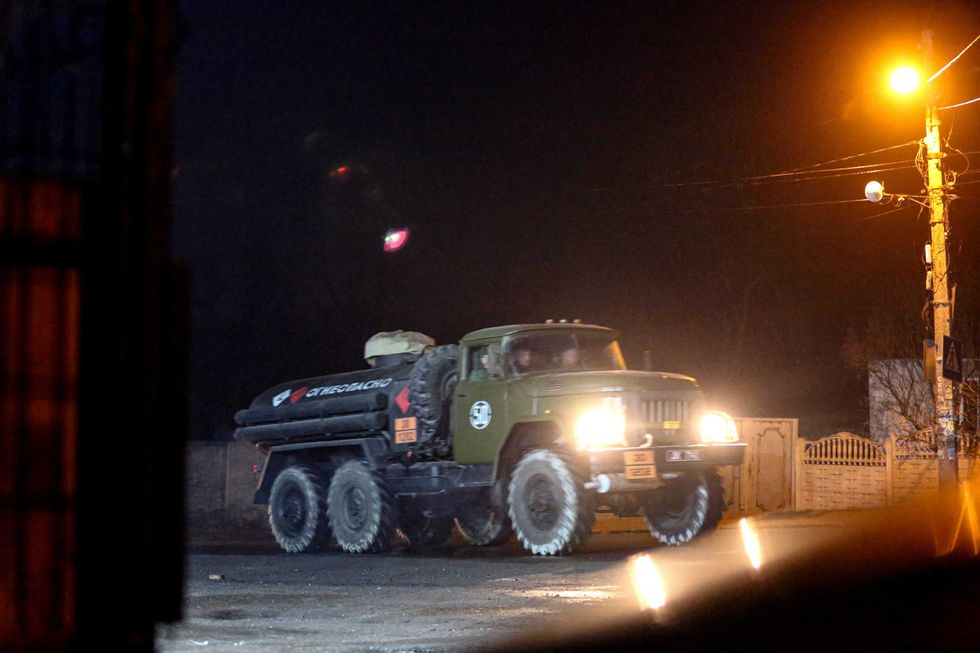 A military truck drives down a street outside Donetsk, the territory controlled by pro-Russian militants, eastern Ukraine, late Tuesday, Feb. 22, 2022