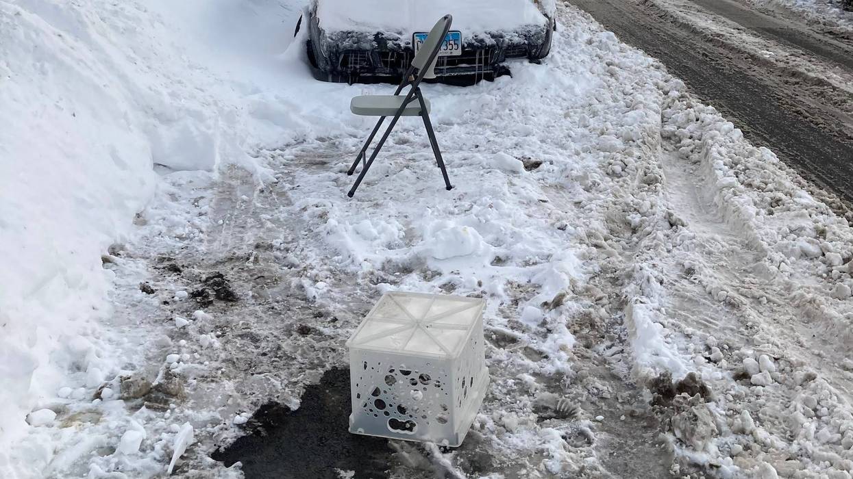 A milk crate and a folding chair hold a parking space in Chicago's Ravenswood neighborhood, February 2021.