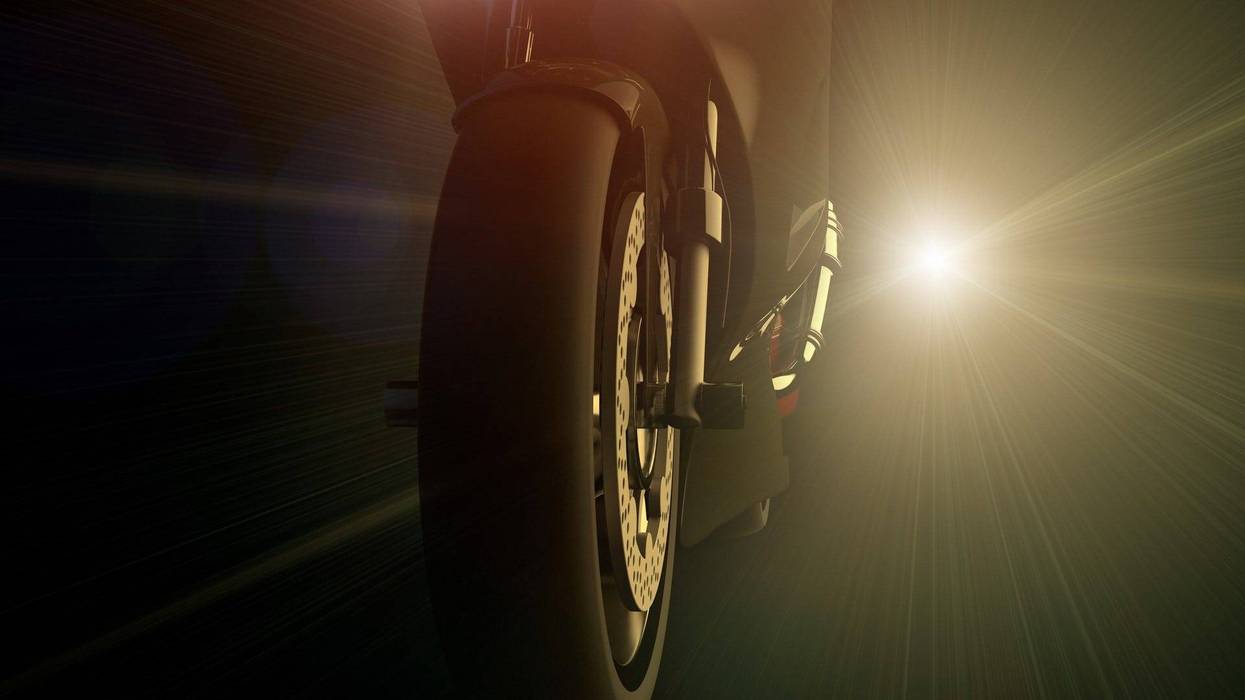 A motorcycle and bright light at night - stock photo