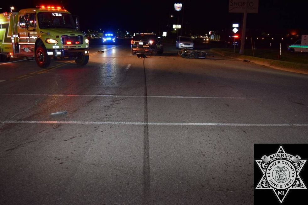 A motorcyclist remains hospitalized with serious injuries on Tuesday, four days after he drove right into the back of a parked police cruiser at the scene of another crash in Lapeer County.