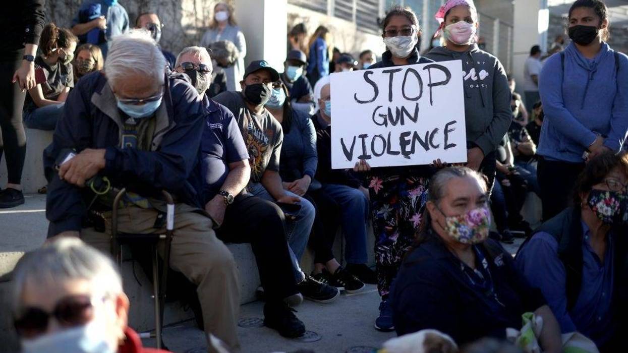 A mourner holds a sign during a vigil for the nine Santa Clara Valley Transportation Authority (VTA) light rail yard shooting victims at San Jose City Hall on May 27, 2021 in San Jose, California.