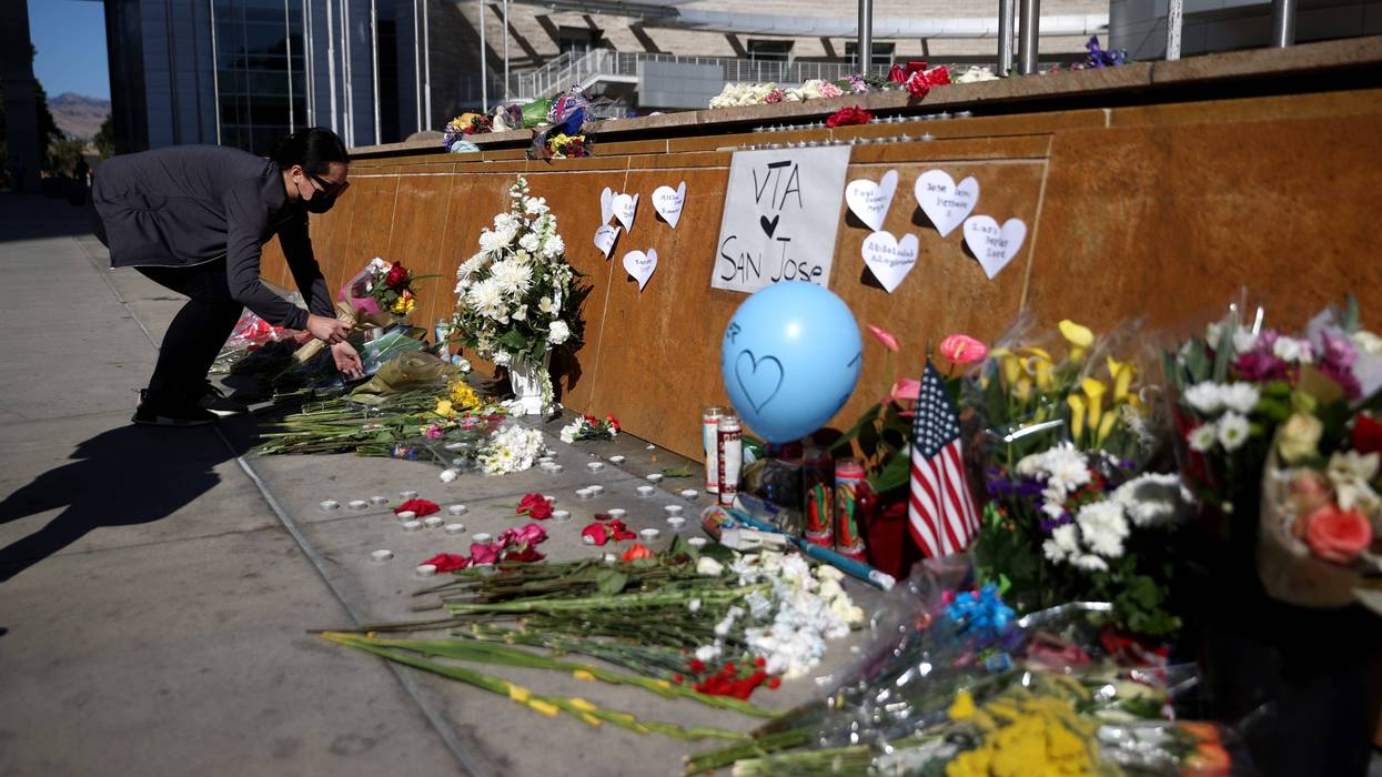 A mourner leaves flowers at a memorial for the nine victims of a shooting at the Santa Clara Valley Transportation Authority (VTA) light rail yard on May 27, 2021 in San Jose, California