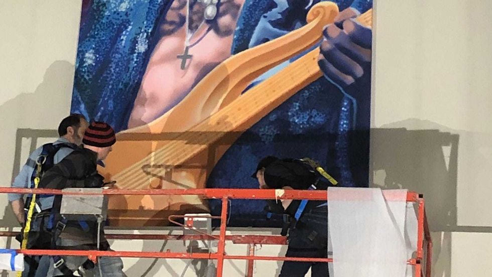 A mural of Prince being installed at MSP