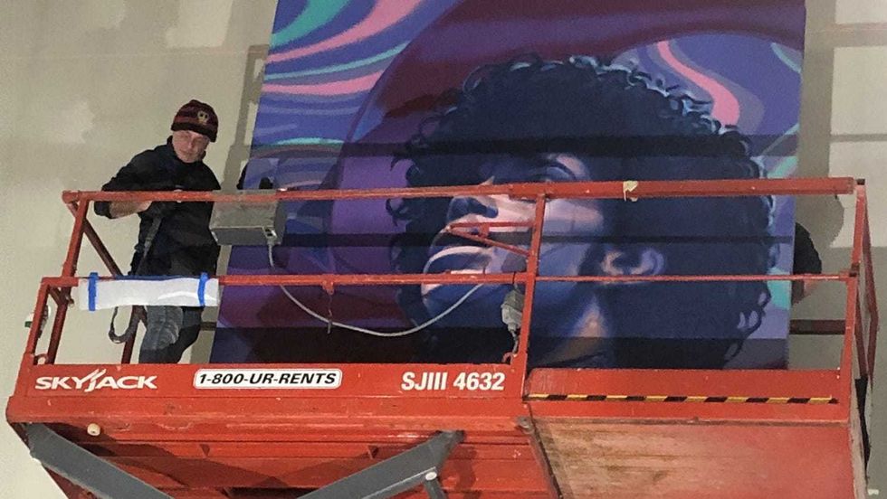 A mural of Prince being installed at MSP