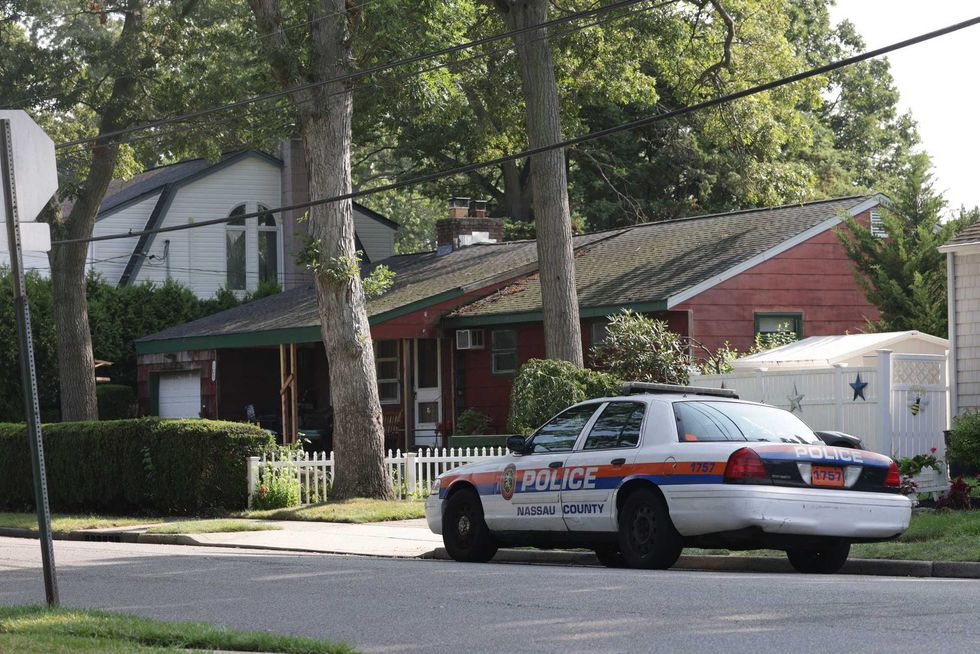 A Nassau County police car is seen parked on First Avenue in Massapequa Park outside the home of Rex Heuermann