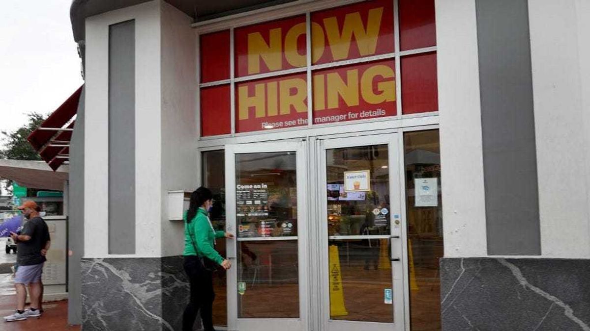 A ''Now Hiring" sign hangs above the entrance to a McDonald's restaurant on November 05, 2021 in Miami Beach, Florida.