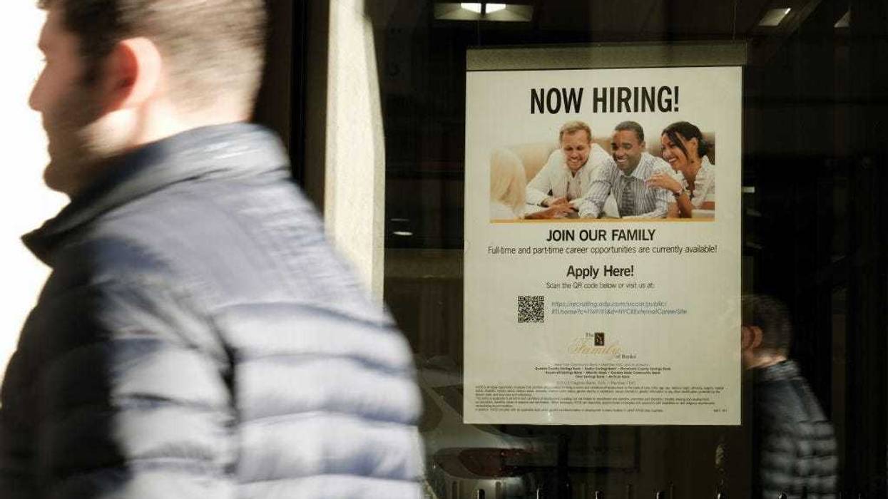 A 'now hiring' sign is displayed in a window of a store in Manhattan on December 02, 2022 in New York City.