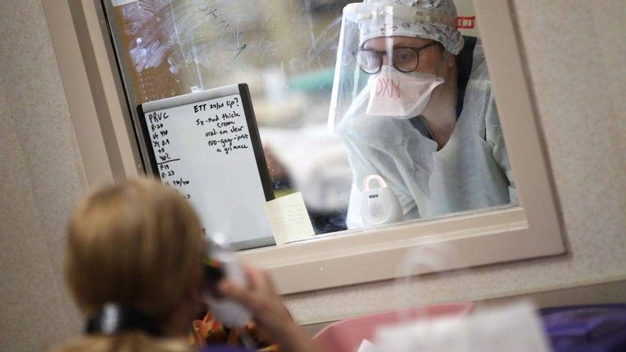 A nurse communicates with a colleague through a window while treating a patient with coronavirus in the intensive care unit at a hospital on May 1, 2020 in Leonardtown, Maryland.
