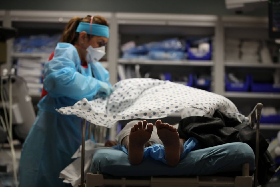 A nurse places a blanket over a patient that had just been admitted to the emergency room at Regional Medical Center on May 21, 2020 in San Jose, California.
