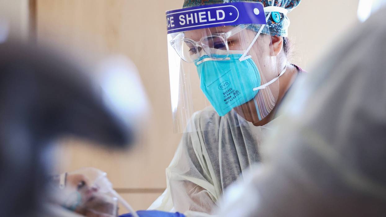 A nurse takes care of a patient with Covid-19