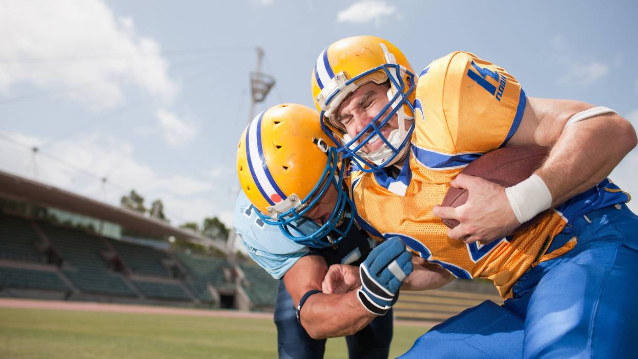 A pair of football players collide mid-game.