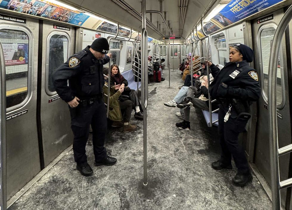 A pair of officers rides the L train on Tuesday night