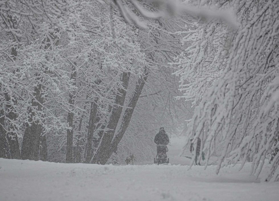 A parent pushes a stroller through the snow in Irvington, Westchester County, on Feb. 13, 2024