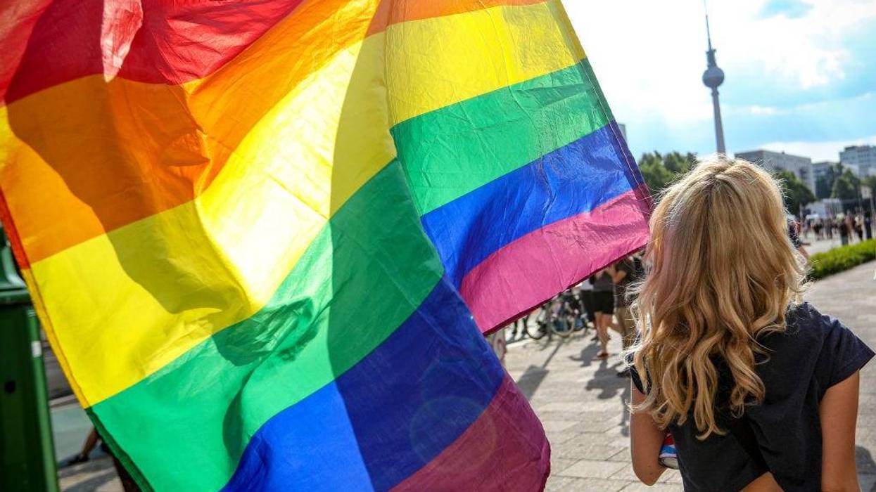 A participant holds the rainbow pride flag in the Queerschutz Now! (Queer Protection Now!) march through Karl-Marx-Allee street in commemoration and celebration of Christopher Street Day on June 26, 2021 in Berlin, Germany. A variety of gay pride marches and gatherings are taking place across the city today, each with its own political or thematic emphasis. The marches are taking place close to the 52nd anniversary of the 1969 riots following a police raid at The Stonewall Inn in New York City that ignited the gay rights movement. (Photo by Omer Messinger/Getty Images)