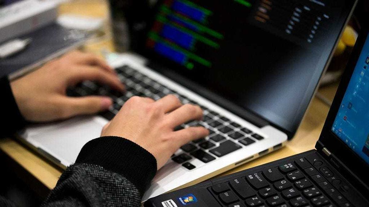 A participant uses a laptop computer as he takes part in the Seccon 2016 final competition on January 28, 2017 in Tokyo, Japan.