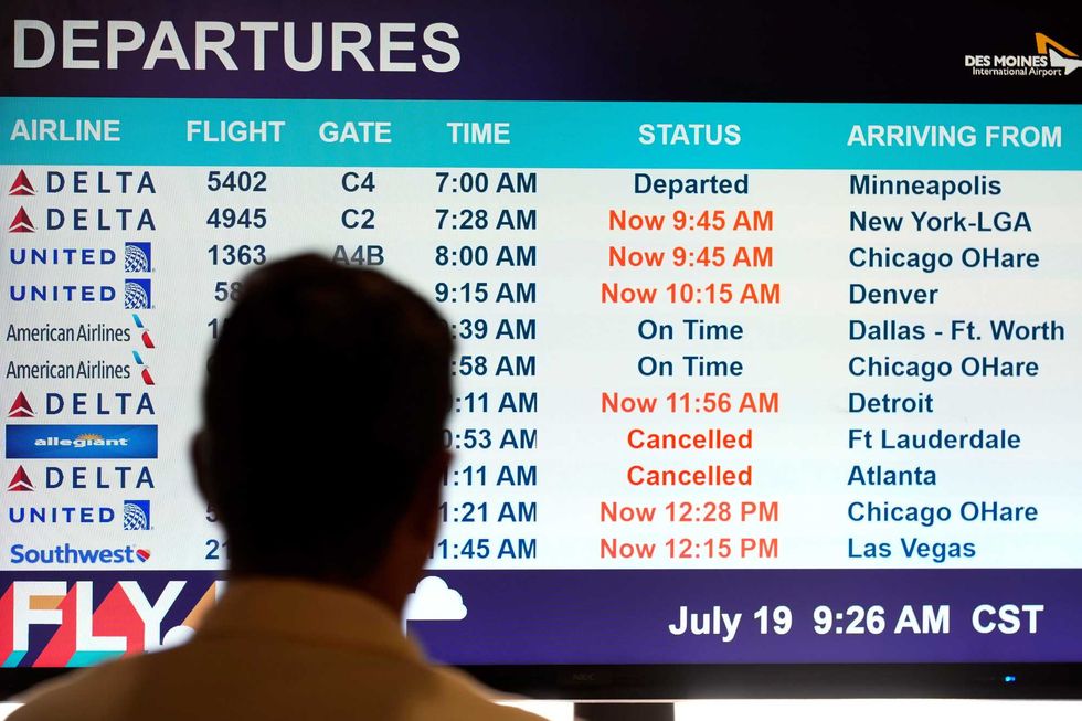 A passenger looks at a departures monitor at the Des Moines International Airport, Friday, July 19, 2024, in Des Moines, Iowa