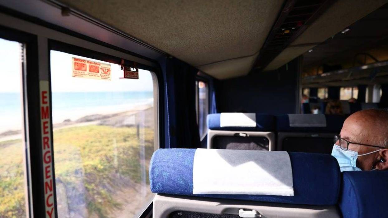 A passenger rides an Amtrak train passing near the Pacific Ocean on November 9, 2021 near Oceanside, California.