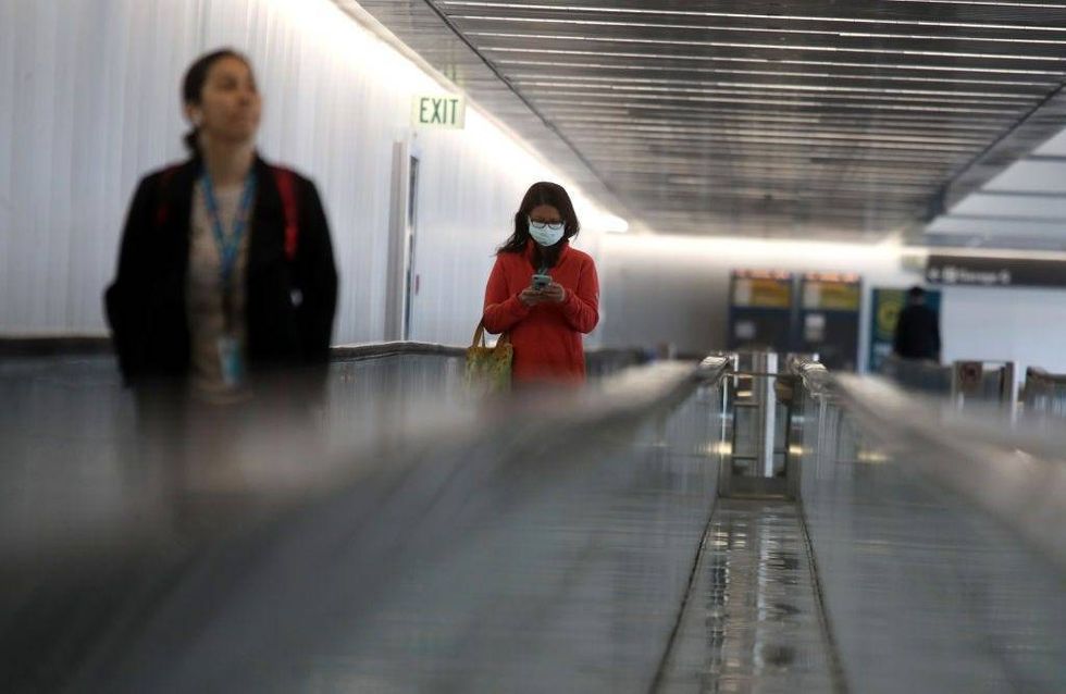 A passenger wears a protective mask as she walks into the international terminal at San Francisco International Airport on March 06, 2020 in San Francisco, California.