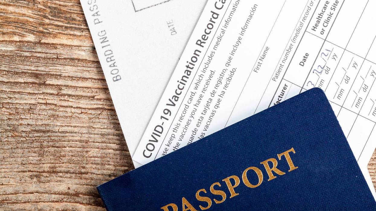 a passport, a boarding pass and a COVID-19 vaccination record card