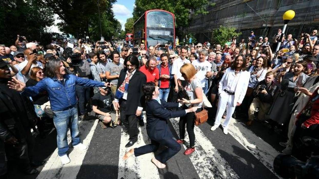 A Paul McCartney impersonator proposes to his girlfriend as a group of Beatles look-alikes recreate the iconic 'Abbey Road' photograph