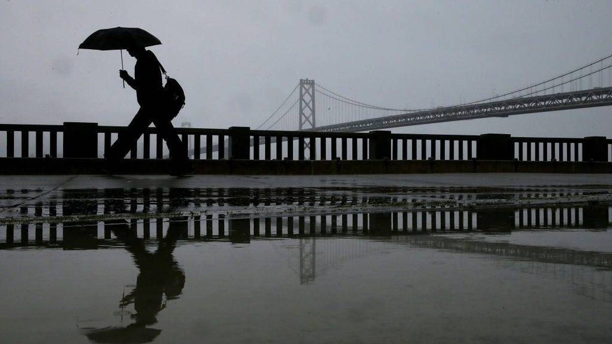 A pedestrian carries an umbrella while walking near the Bay Bridge on February 6, 2014 in San Francisco, California.