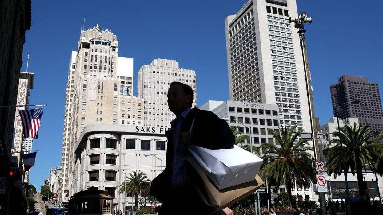 A pedestrian carries shopping bags as he walks through Union Square on February 22, 2011 in San Francisco, California.