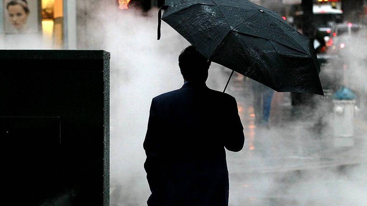 A pedestrian holds an umbrella as he waits to cross the street in on February 17, 2011 in San Francisco, California.