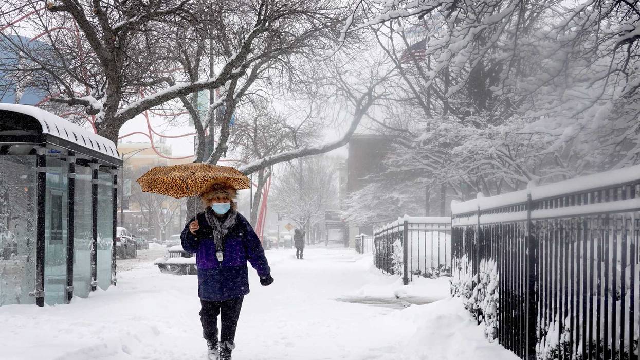 A pedestrian navigates a snow-covered sidewalk on Feb. 2, 2022, in Chicago.