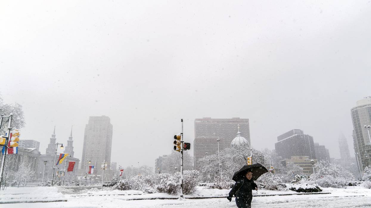 A pedestrian walks through snow and slush on March 7, 2018, in Philadelphia, the second nor'easter to hit the Northeast within a week.