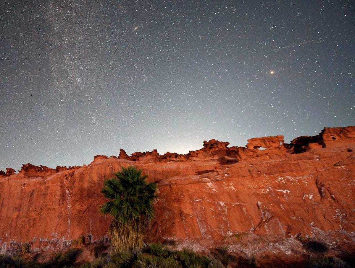 A Perseid meteor (R) streaks across the sky over the planet Mars above the red sandstone area known as Little Finland, about 110 miles northeast of Las Vegas, early on August 12, 2020 in Gold Butte National Monument, Nevada.