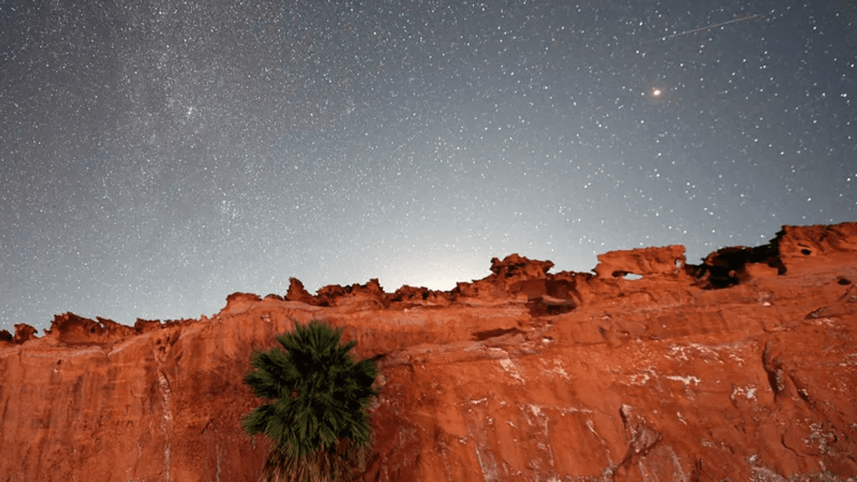 A Perseid meteor (R) streaks across the sky over the planet Mars above the red sandstone area known as Little Finland, about 110 miles northeast of Las Vegas, early on August 12, 2020 in Gold Butte National Monument, Nevada.