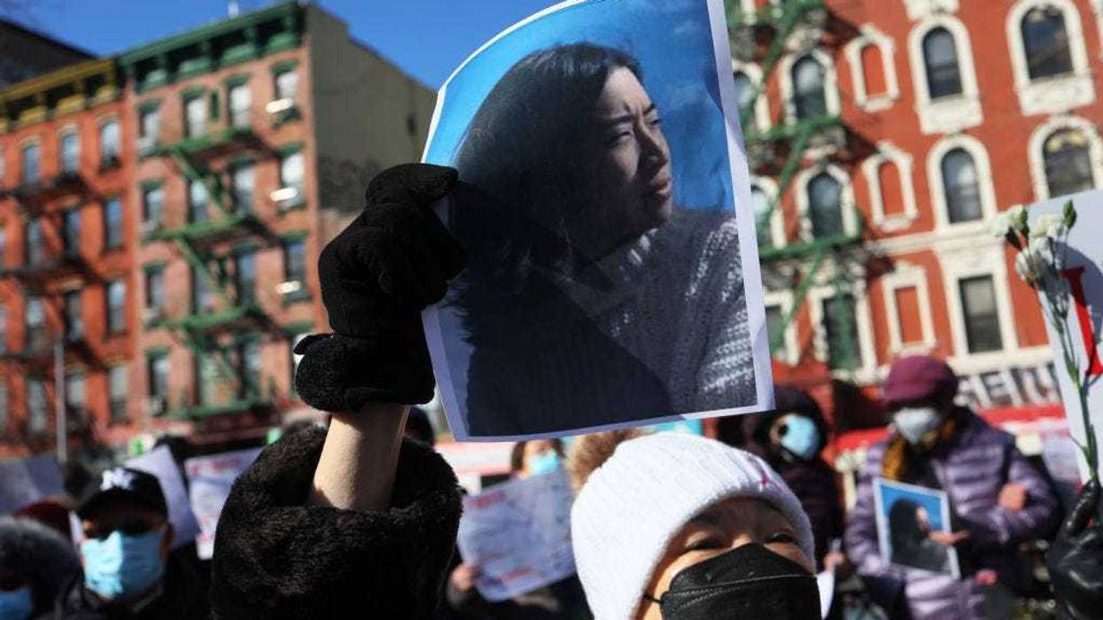 A person holds a photo of Christina Yuna Lee as people gather for a rally protesting violence against Asian-Americans at Sara D. Roosevelt Park on February 14, 2022 in the Chinatown neighborhood in New York City. Community members and leaders gathered to protest violence against the Asian-American community in the wake of the murder of 35-year old Christina Yuna Lee.