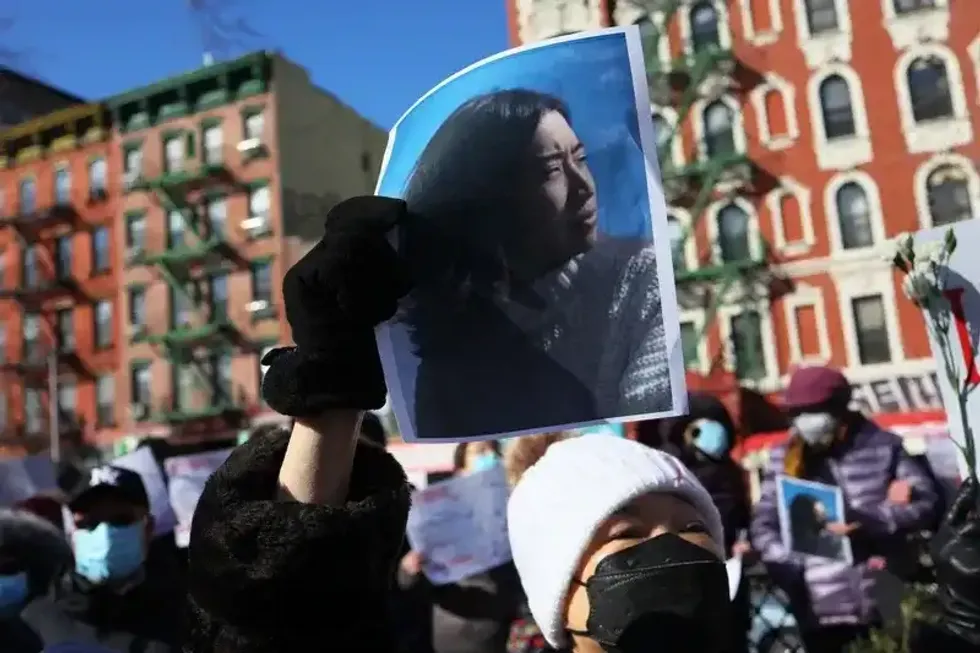 A person holds a photo of Christina Yuna Lee as people gather for a rally protesting violence against Asian Americans at Sara D. Roosevelt Park in Chinatown on Feb. 14, 2022.