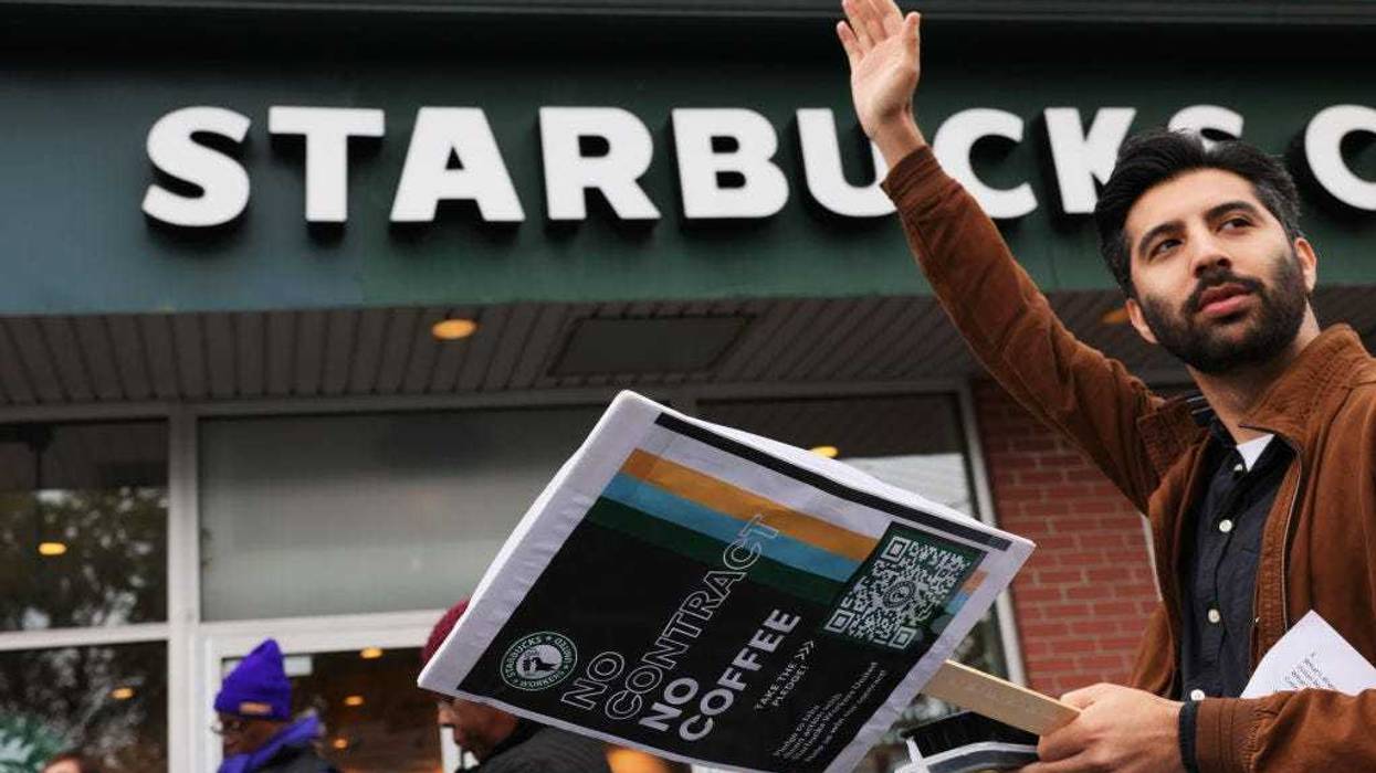 A person holds a sign as Starbucks workers hold a rally on October 05, 2022 in New York City. Starbucks Workers United were joined in solidarity by various unions as they held a rally outside of a Staten Island store, slated to close for renovations later this month. They are calling for the right to negotiate employment terms and want an end to the union busting campaign that is being used against workers throughout the country. (Photo by Michael M. Santiago/Getty Images)