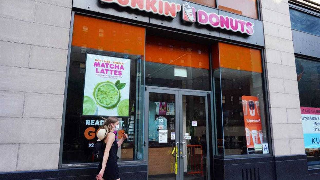 A person in a protective mask walks by a temporarily closed Dunkin' Donuts as New York City moves into Phase 3 of re-opening following restrictions imposed to curb the coronavirus pandemic on July 13, 2020.
