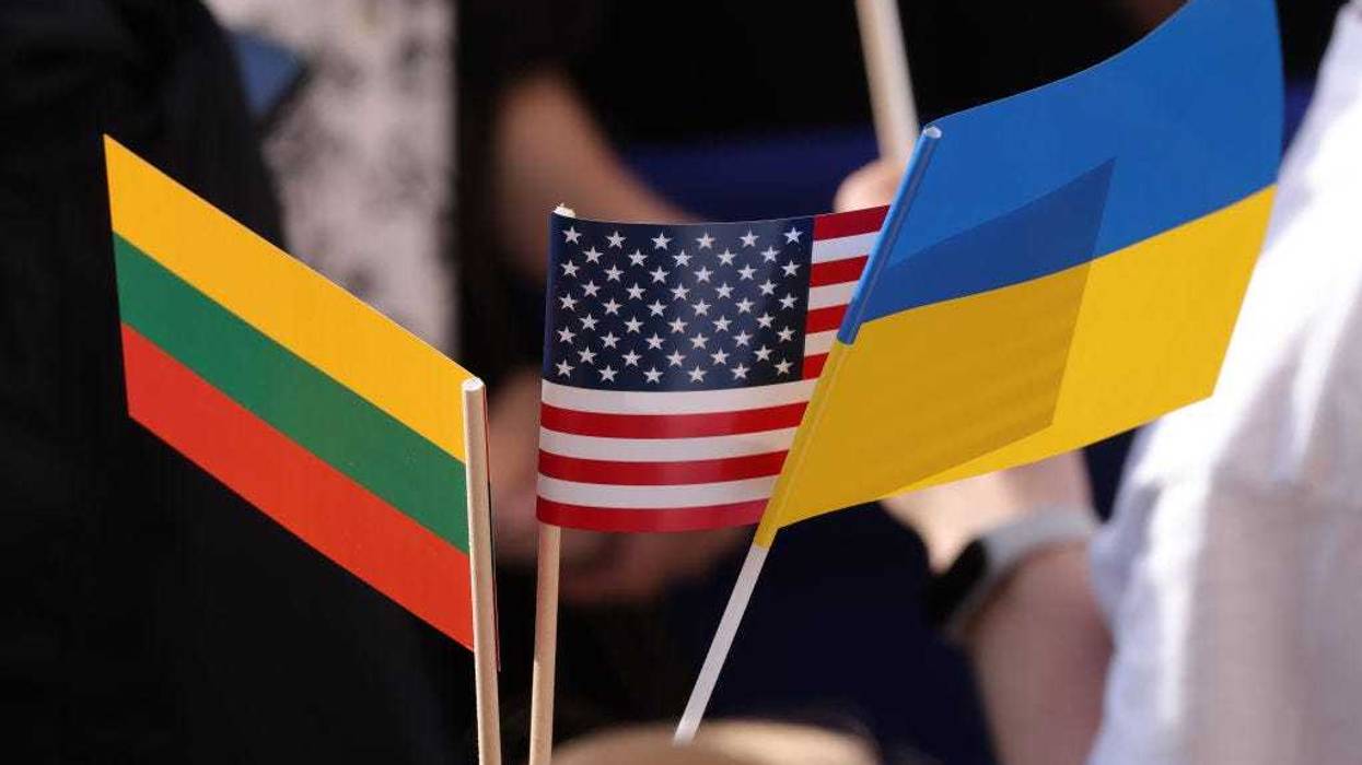 A person in the crowd holds U.S., Lithuanian and Ukrainian flags prior to the arrival of U.S. President Joe Biden, who spoke to a crowd at Vilnius University, on July 12, 2023 in Vilnius, Lithuania. Biden, who was in Vilnius to participate in the 2023 NATO Summit, lauded Lithuania and the Baltic countries for attaining freedom following the collapse of the Soviet empire.