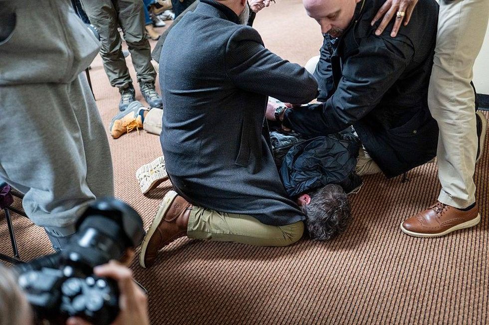 A person is subdued after attempting to attack Rep. Ilhan Omar (D-MN) during a town hall meeting at the Urban League Twin Cities facility on January 27, 2026 in Minneapolis, Minnesota. A person holding a syringe charged Omar