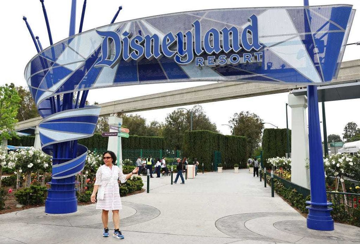 A person poses for a photo at an entrance to Disneyland on April 24, 2023 in Anaheim, California.