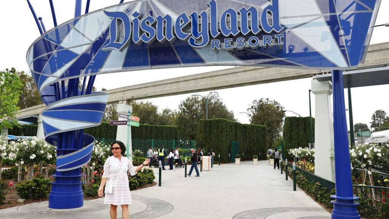 A person poses for a photo at an entrance to Disneyland on April 24, 2023 in Anaheim, California.