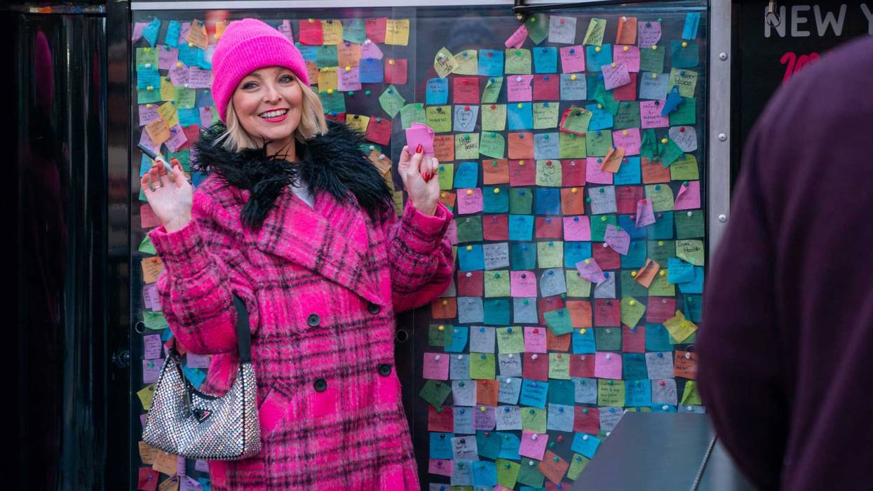 A person poses with their wish at the New Year's Eve Wishing Wall in Times Square on Dec. 20, 2023 in New York City.