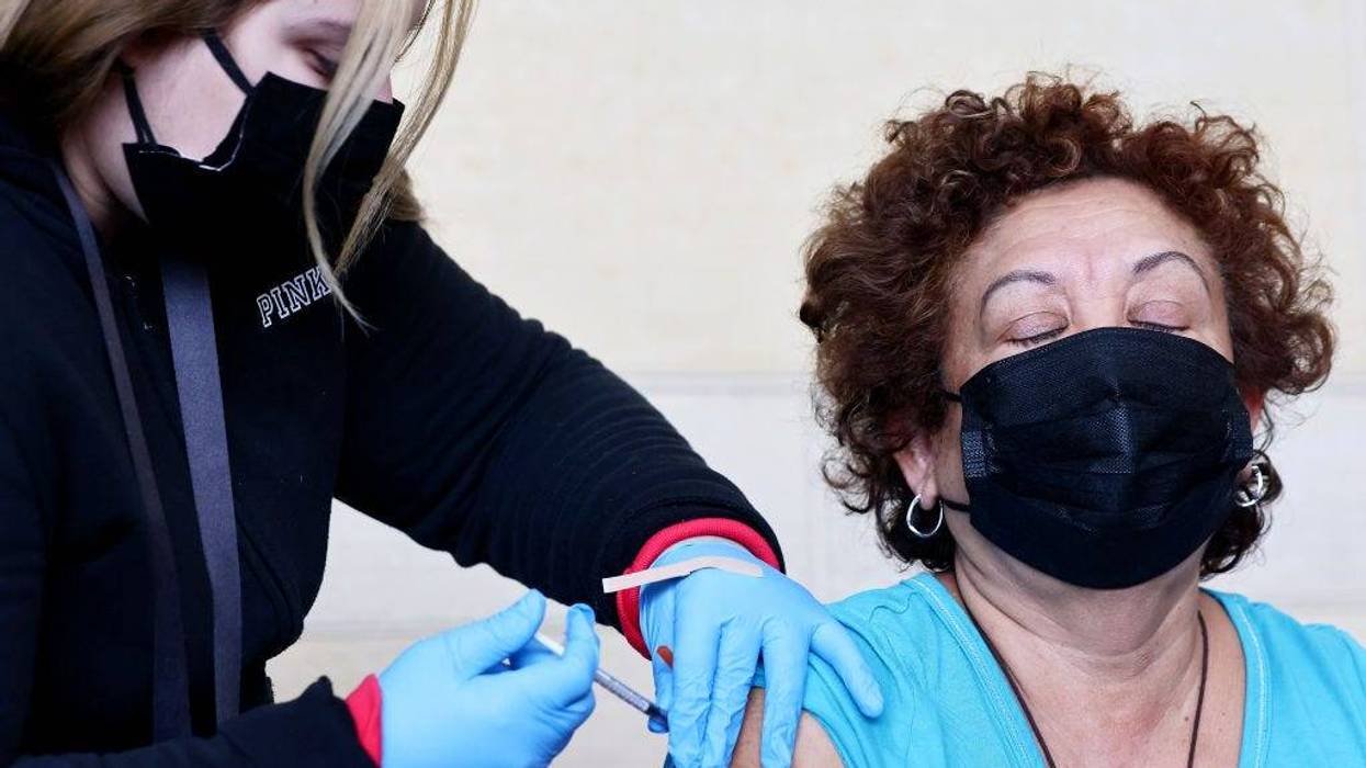 A person receives a COVID-19 vaccination dose, during a free distribution of COVID-19 rapid test kits for those who received vaccination shots or booster shots, at Union Station on January 7, 2022 in Los Angeles, California.