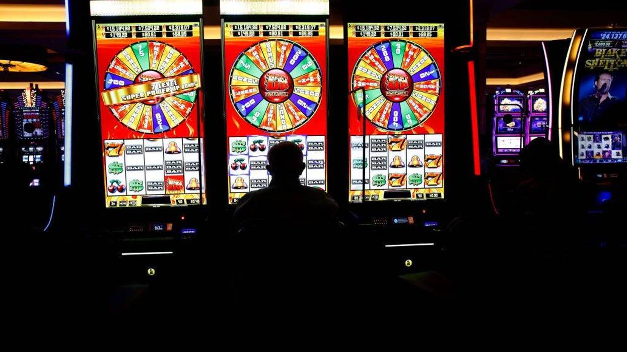 A person sits at the slot machines on the casino floor.