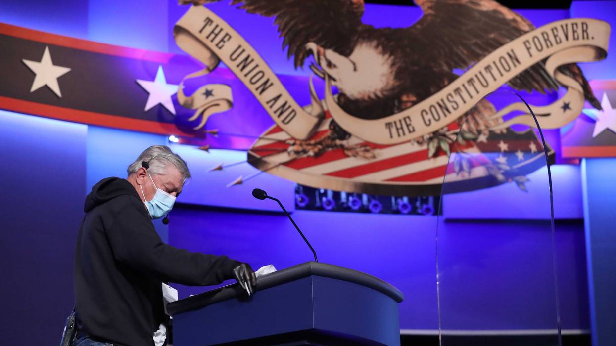 A person uses disinfecting wipes to clean the lectern that will be used by President Donald Trump during the second presidential debate at the Curb Event Center on the campus of Belmont University on October 22, 2020 in Nashville, Tennessee. President Trump and Democratic presidential nominee Joe Biden are scheduled to square off for the final debate, 12 days before Election Day.