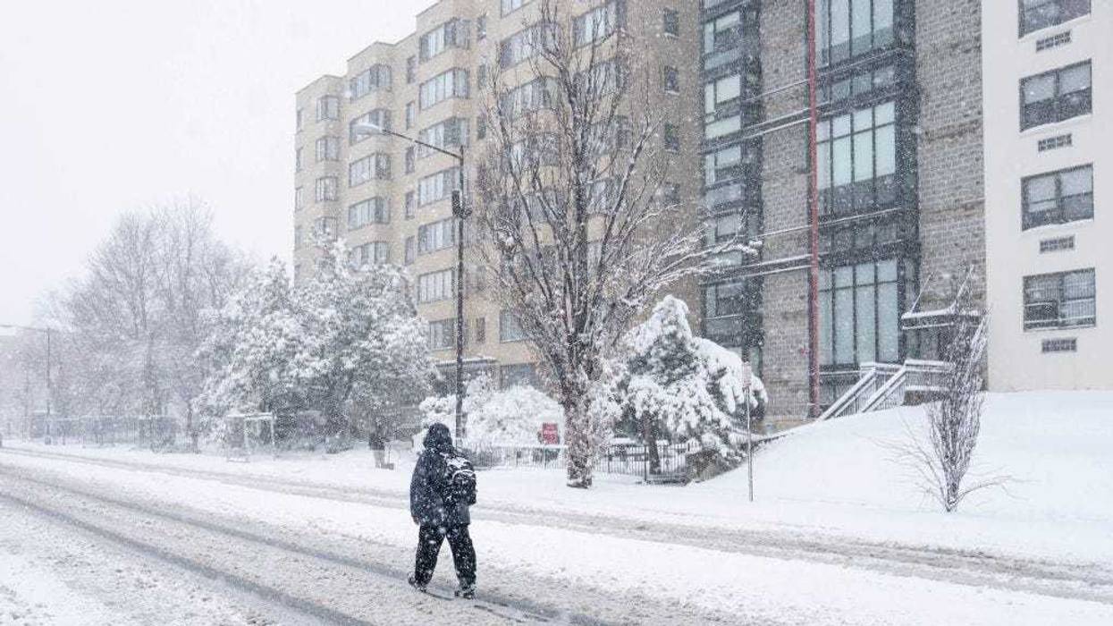 A person walks in the middle of 16th street during a snowstorm on January 3, 2022 in Washington, DC.