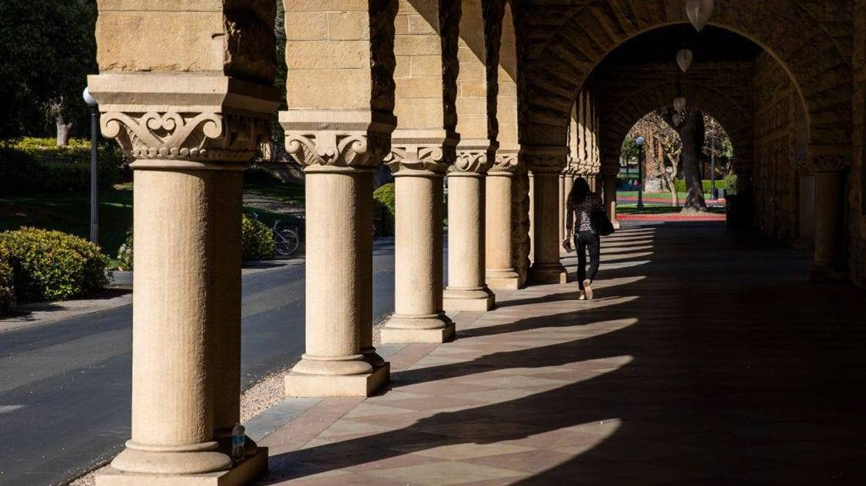 A person walks past archways during a quiet morning at Stanford University on March 9, 2020 in Stanford, California.