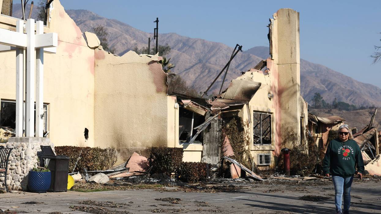 A person walks past the remains of senior living facility which was destroyed in the Eaton Fire, as wildfires cause damage and loss through the LA region on January 11, 2025 in Pasadena, California.