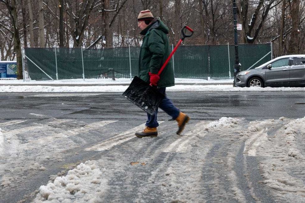 A person walks with a shovel after an overnight snowstorm on Feb. 9, 2025 in Brooklyn.