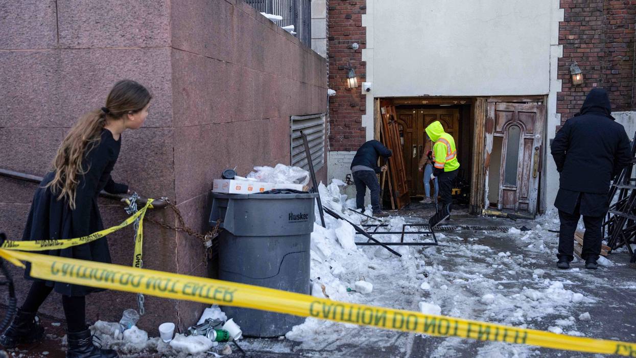 A person watches the scene where a car slammed into the entrance of the Chabad Lubavitch world headquarters, Jan. 29, 2026, in New York.