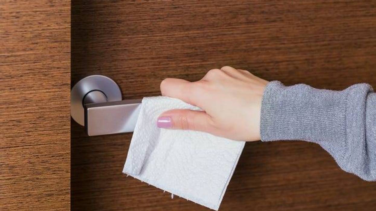 A person wiping down their door knob