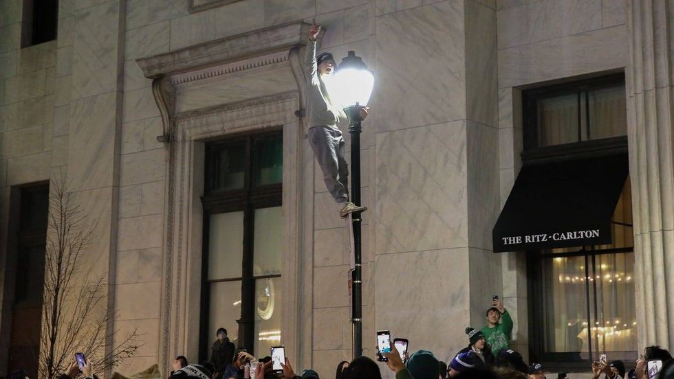 A Philadelphia Eagles fan climbed a pole outside the Ritz-Carlton Hotel after the Eagles defeated the San Francisco 49ers in the NFC Championship Game on Sunday.